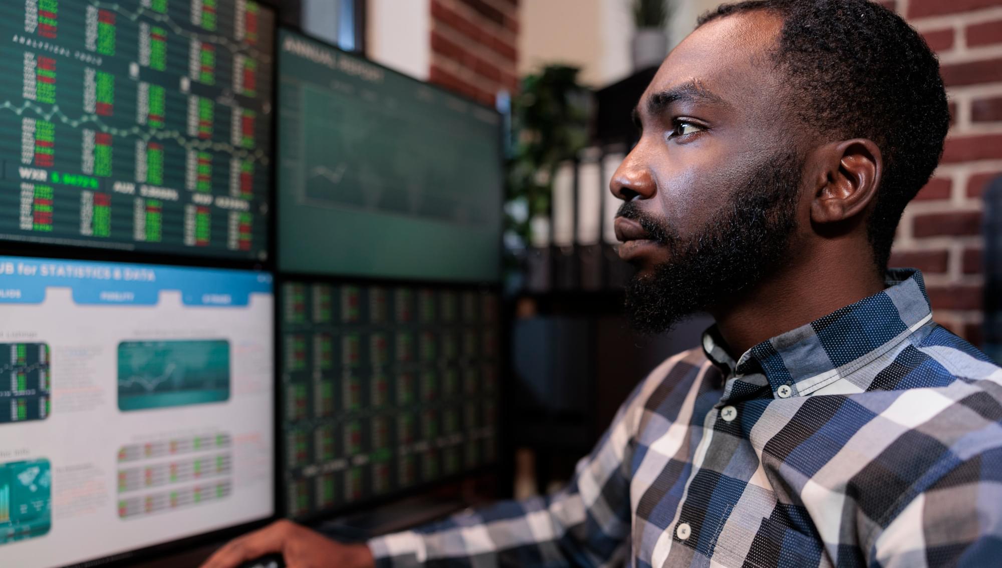 A man day trading with many computer screens