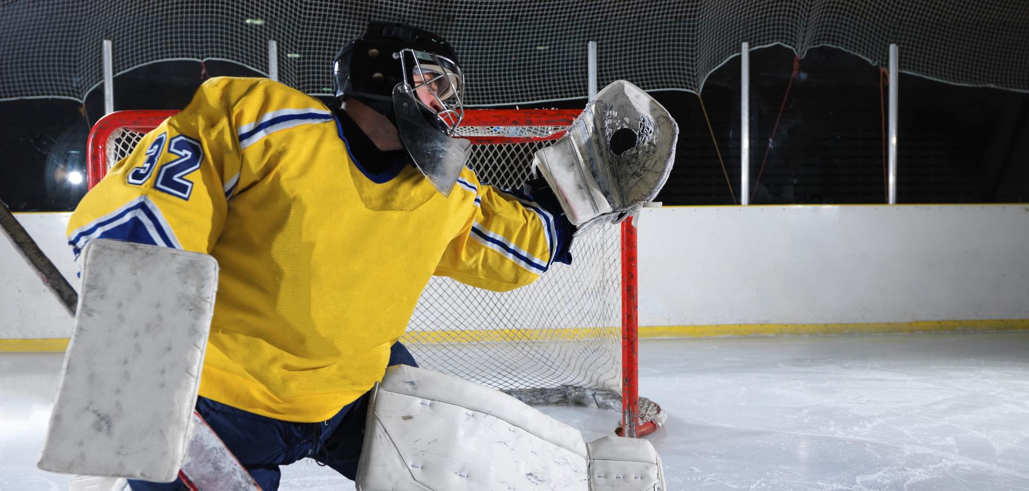 A hockey goalie catching a puck