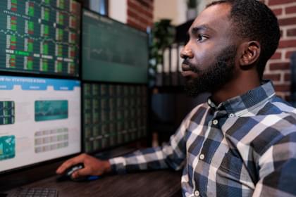 A man day trading with many computer screens