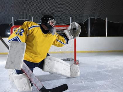 A hockey goalie catching a puck